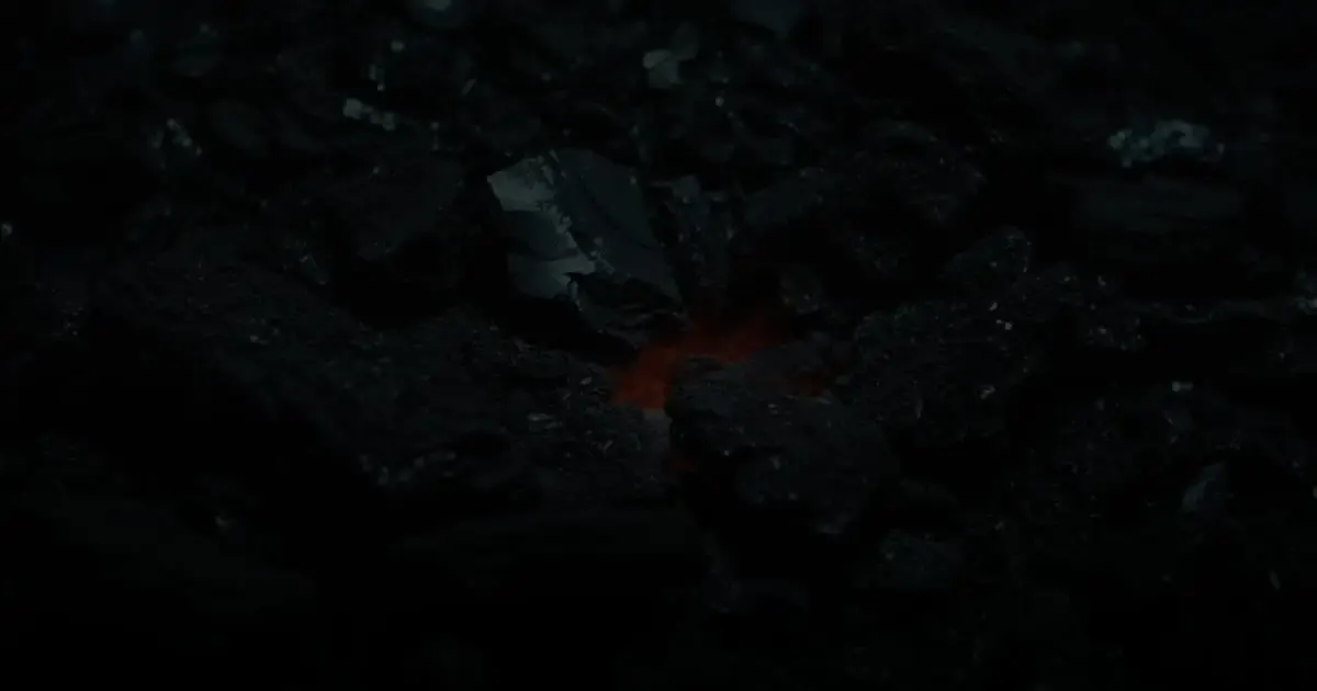 A lone ember glowing under scattered forge coal, like the leasing, rent and maintenance tasks a property management website brings together