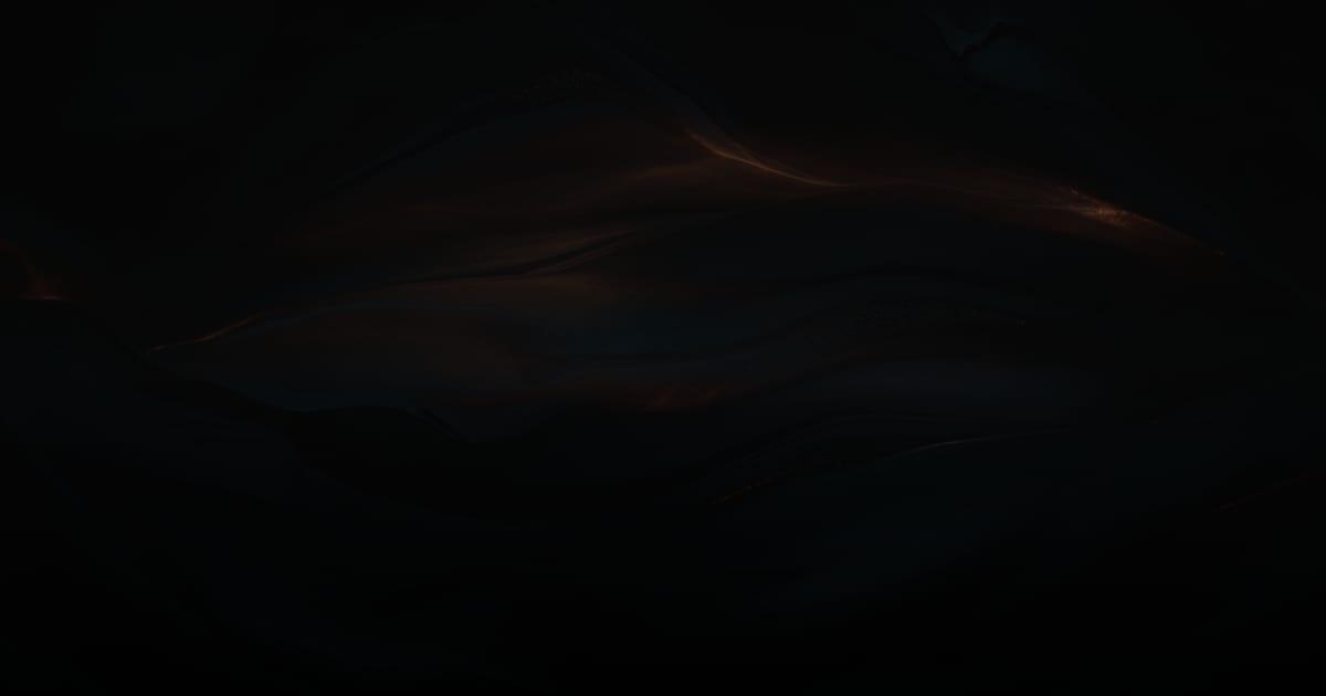 Folded dark steel catching warm light along each fold, illustrating the discovery, scope, build and launch stages of custom software development